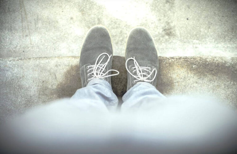 Blick auf Füße mit grauen, geschnürten Schuhen